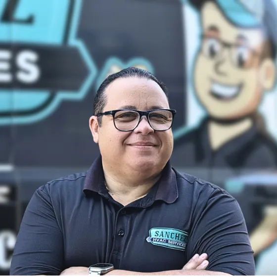 Pedro Sanchez, owner of Sanchez HVAC Services, standing in front of a company van